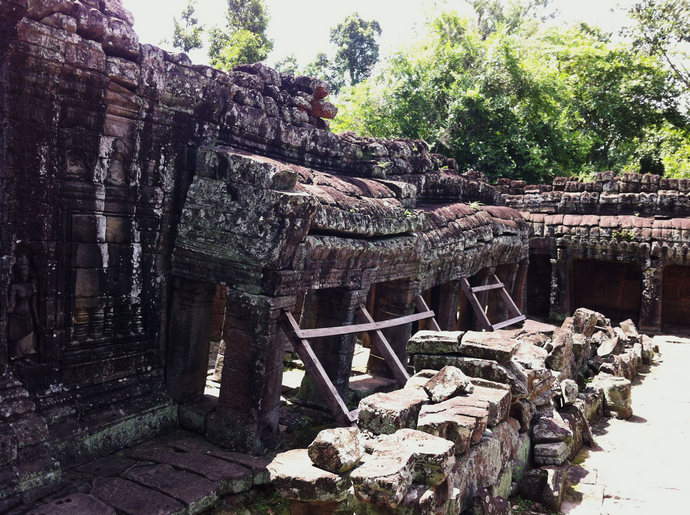 The Side wall of an ancient temple held up by wood to prevent the sculpture from crashing completely