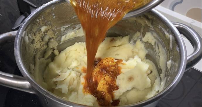 Adding spiced and melted butter to mash