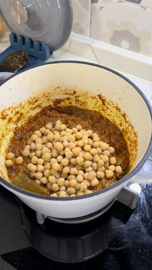 adding chickpeas to the curry for chickpea indian curry on the cravers guide